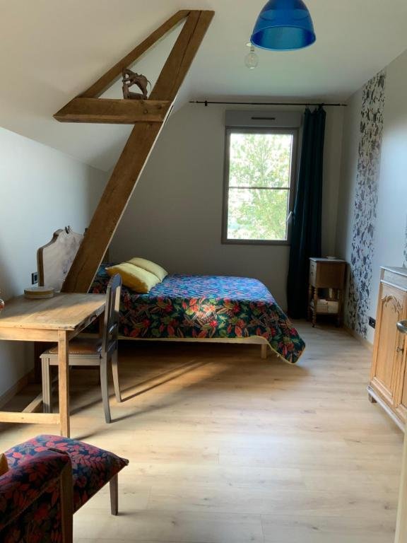 Chambre avec poutres apparentes, parquet et lit double coloré